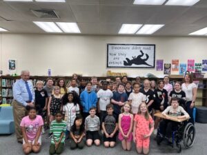 Children in a school library posing with our attorneys