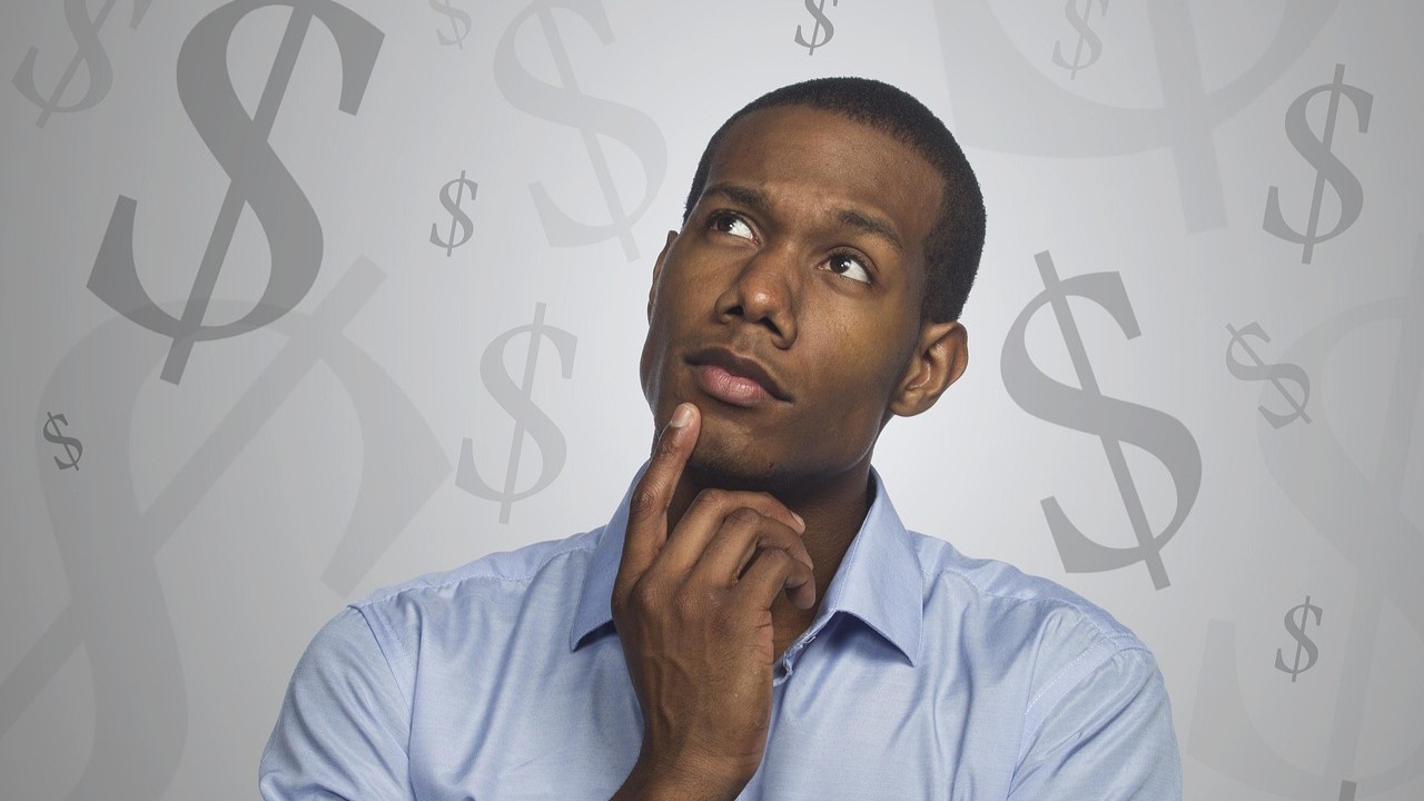 man-5982512_1280 man thinking with money symbols around him.